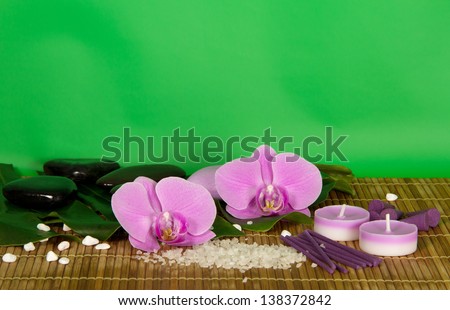 Orchid flowers, set for Spa on a bamboo cloth. Green background