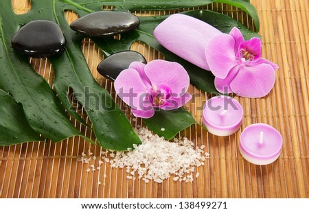 Monstera leaf, orchid and set for Spa on a bamboo cloth