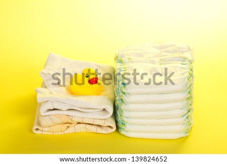 Disposable diapers, clothes and a rubber duckling, on the yellow