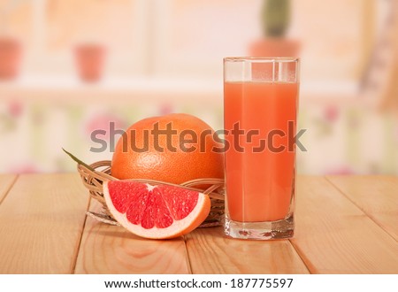Glass of fresh juice and grapefruit slice close-up in the kitchen