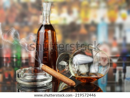 Whisky in glasses and smoking cigar on bar background