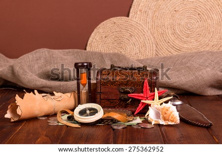 Old compass, treasure chest, knife, money and starfishes on wooden table