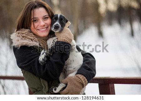 dog in the hands of the owner smiling girl