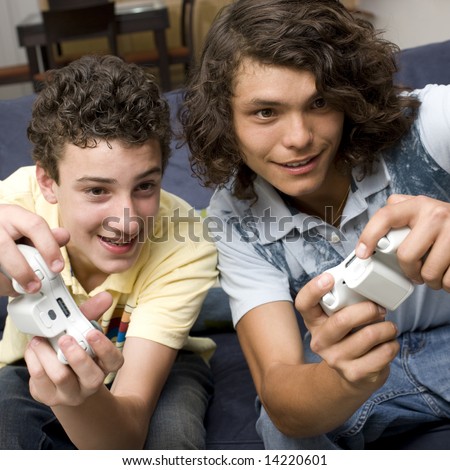 Teens play video games on a couch