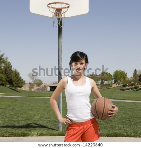 Teen girl with basketball hangs out at a park
