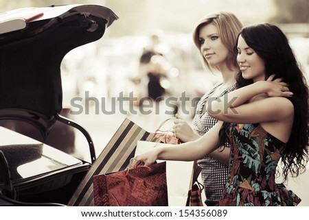 Two young female shoppers at the car