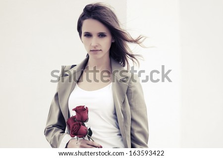 Sad young woman with a roses