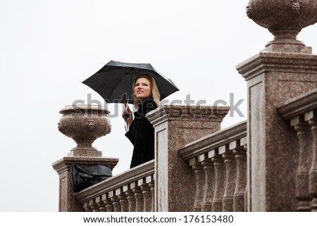 Happy woman with umbrella in the rain