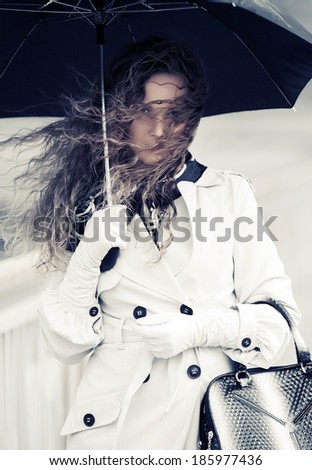Beautiful woman with umbrella in the rain
