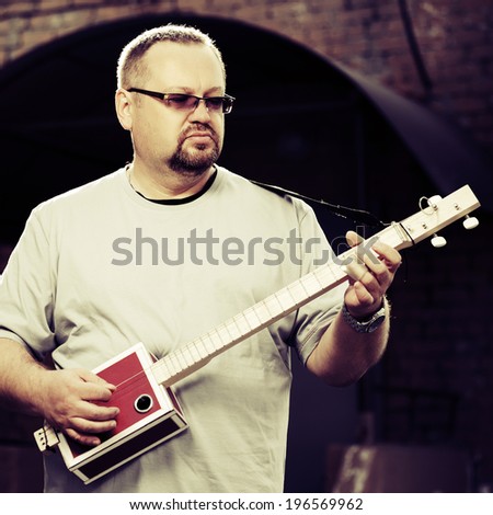 Man playing his cigar box guitar