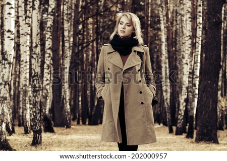 Blond fashion woman walking in autumn forest