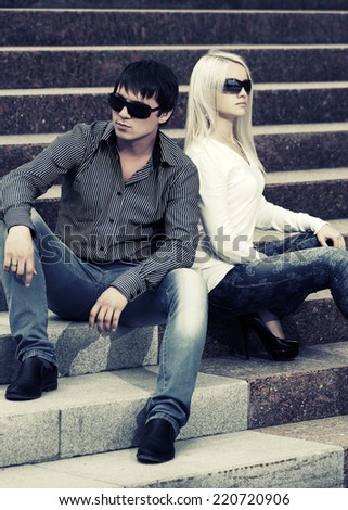 Young fashion man and woman in conflict sitting on the steps