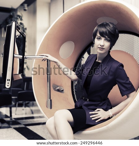 Young fashion business woman sitting on computer chair in office