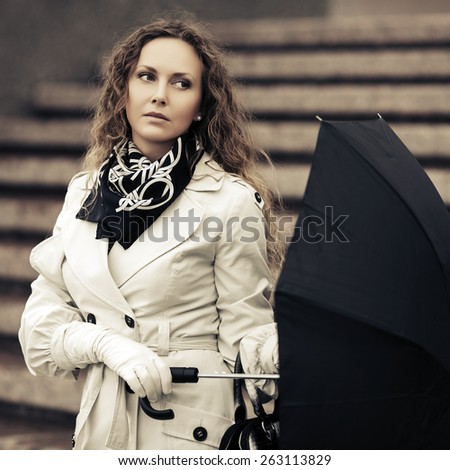 Beautiful fashion woman with umbrella on a city street