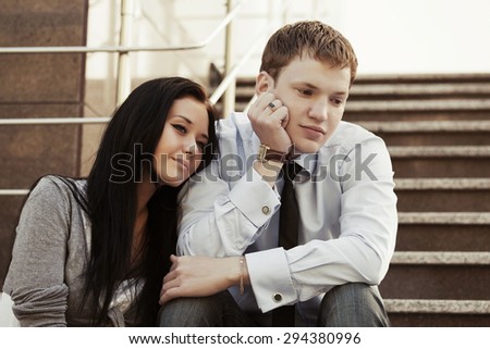 Sad young couple in depression sitting on the steps