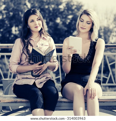 Young fashion women with a book and digital tablet computer