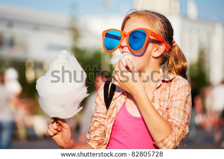 Similar – Image, Stock Photo Cheerful girl eating cotton candy on street