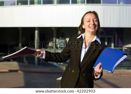 Happy businesswoman with a folders against an airport terminal.