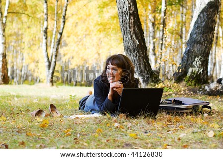 Young businesswoman using laptop on nature.