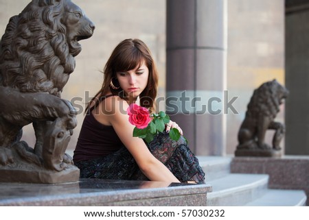 Sad young woman with rose.