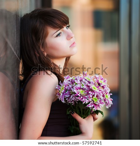 Sad young woman with chrysanthemum.