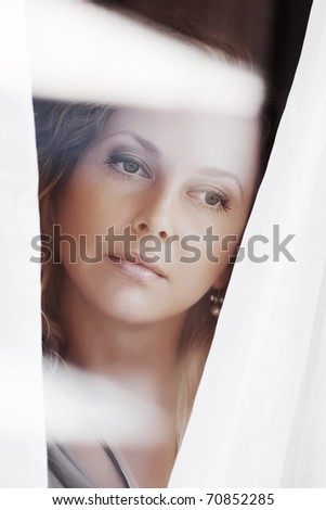 Sad woman looking through a window