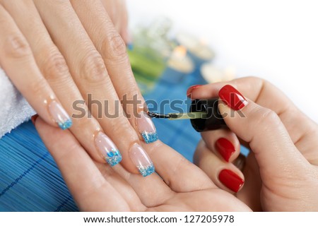 Manicure - manicure treatment, applying cuticle oil on woman nails with very interesting nail art.