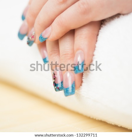 Manicure - Beauty treatment photo of nice manicured woman fingernails with blue gel nail polish. Selective focus.