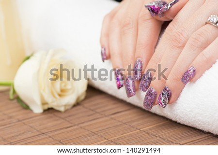 Manicure - Professionally manicured woman fingernails, with engagement ring. Studio shot. Selective focus.