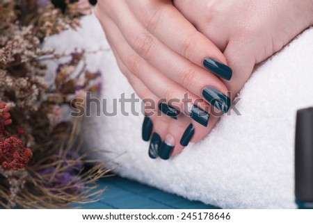 Manicure - Beauty treatment photo of nice manicured woman fingernails. Very nice nail art with petroleum blue nail polish. Selective focus.