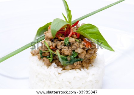 spicy pork fried with hot basil on rice garnish with basil leaves