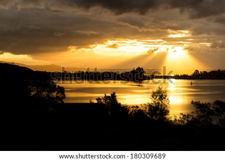 Bright sunset beams and dramatic sky, Lake Rotorua - New Zealand