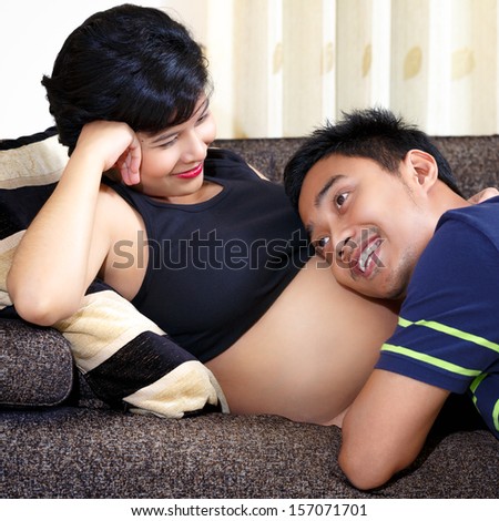 Happy future dad listening the belly of his pregnant wife
