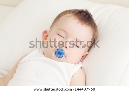 Adorable sleeping baby on the pillow with pacifier