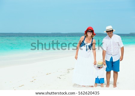 Happy family of three with baby having tropical vacation on Maldives