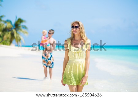 Family walking on the tropical beach on Maldives