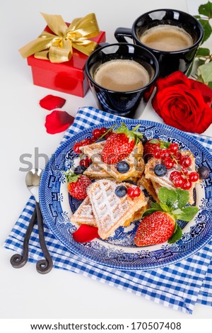 Heart shaped waffles and coffee for romantic breakfast with strawberries, red rose and gift box, valentines day