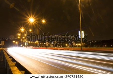 Car light streaks on a bridge over Vltava river in Prague at night