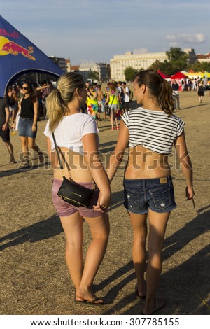 PRAGUE - AUGUST 15, 2015: Two girls holding hands at Letna park during the fifth Prague Pride 2015 with up to 35,000 people marching through the city to Letna park