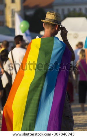 PRAGUE - AUGUST 15, 2015: A man with a hat and a large rainbow flag at Letna park on the fifth Gay Prague Pride 2015