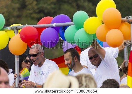 PRAGUE - AUGUST 15, 2015: Attractive men on a decoated car surrounded by balloons waving the crowd from one of the decorated cars of the fifth Prague Pride 2015.Up to 35,000 people attended the parade