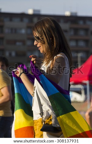 PRAGUE - AUGUST 15, 2015:  A girl with a big rainbow flag at Letna park on the fifth Gay Prague Pride 2015 during the outdoor concert