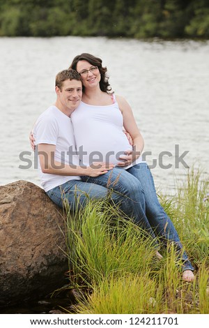 Maternity photos of a couple outdoors in summer time - 8 months pregnant