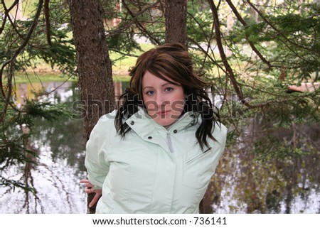 Young woman outdoors posing against trees