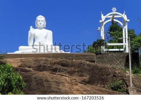 Big white statue of Buddha on the rock in Mihintale, Sri Lanka