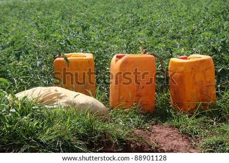 Orang plastic fuel cans on the green field