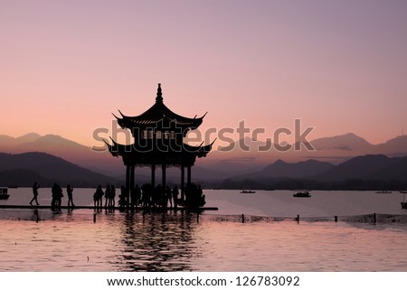 ancient pavilion on the west lake with sunset in hangzhou,China.