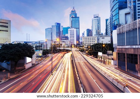 modern urban city traffic trails with cityscape background.
