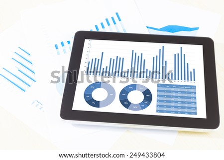 graph display in digital tablet and paper, pen,smartphone. Above view shot.