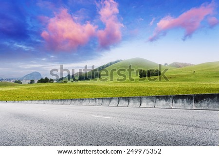 Road through meadow with cloud and sky background